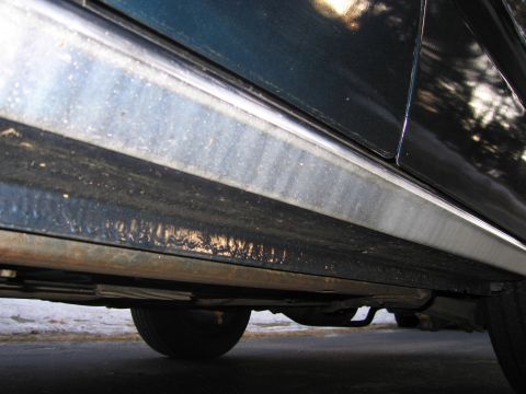 1991 Ford LTD Crown Victoria - Undercarriage view of a vehicle's rocker panel, revealing signs of wear and rust.