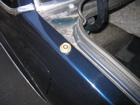 1991 Ford LTD Crown Victoria - Close-up of the trunk edge of a dark blue 1991 Ford Crown Victoria LTD, showing a cracked panel and a fastener.