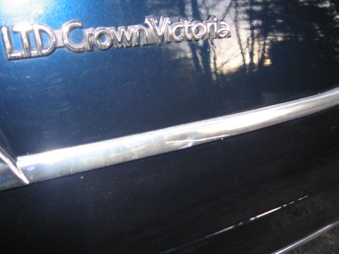 1991 Ford LTD Crown Victoria - Chrome emblem reads LTD Crown Victoria on the car's bodywork, with reflections of the outdoors.