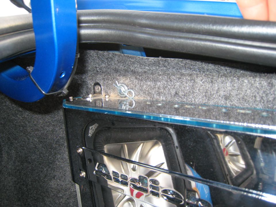 Car trunk showing a Kicker subwoofer with chrome grille and blue accents