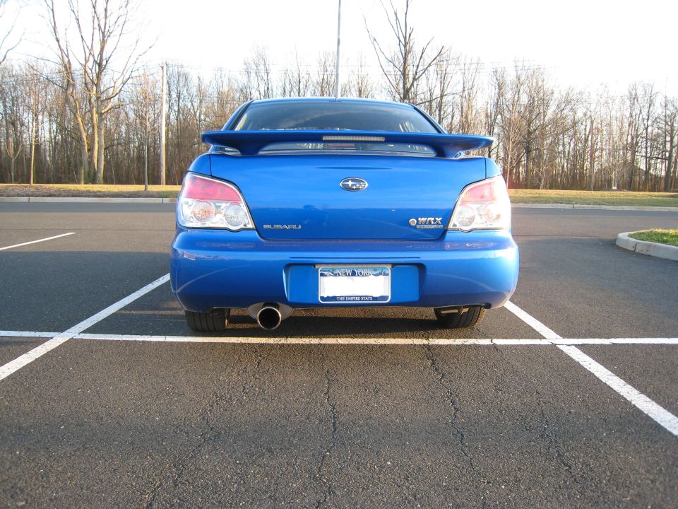 Blue Subaru WRX parked in a lot, rear view. Single exhaust pipe visible