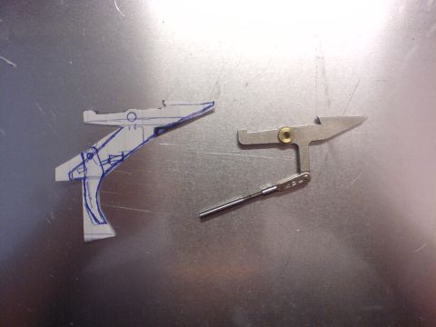 1985 Ford Bronco - A metal lever mechanism and a paper blueprint are laid out on a metallic surface.