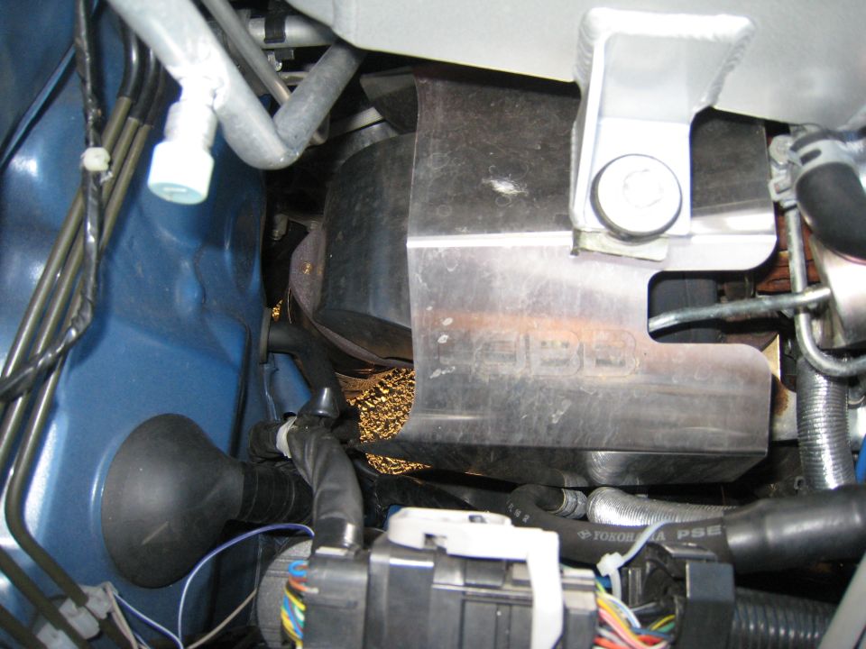 Stainless turbo heat shield and gold heat tape in a blue engine bay