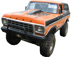 1979 Ford Bronco - This lifted Ford Bronco features a custom hood scoop and large off-road tires, suggesting it's built for terrain.
