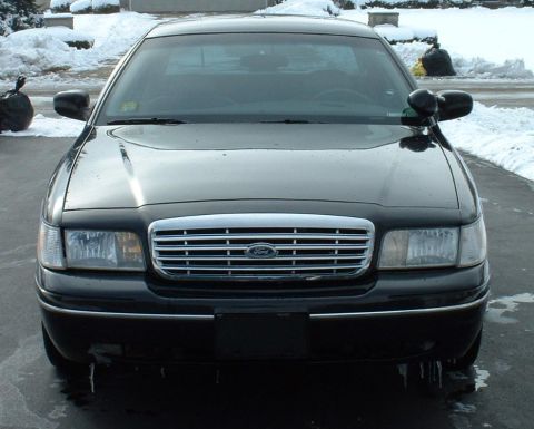 1998 Ford Crown Victoria - Frontal view of a black 1998 Ford Crown Victoria parked outdoors with snow on the ground.