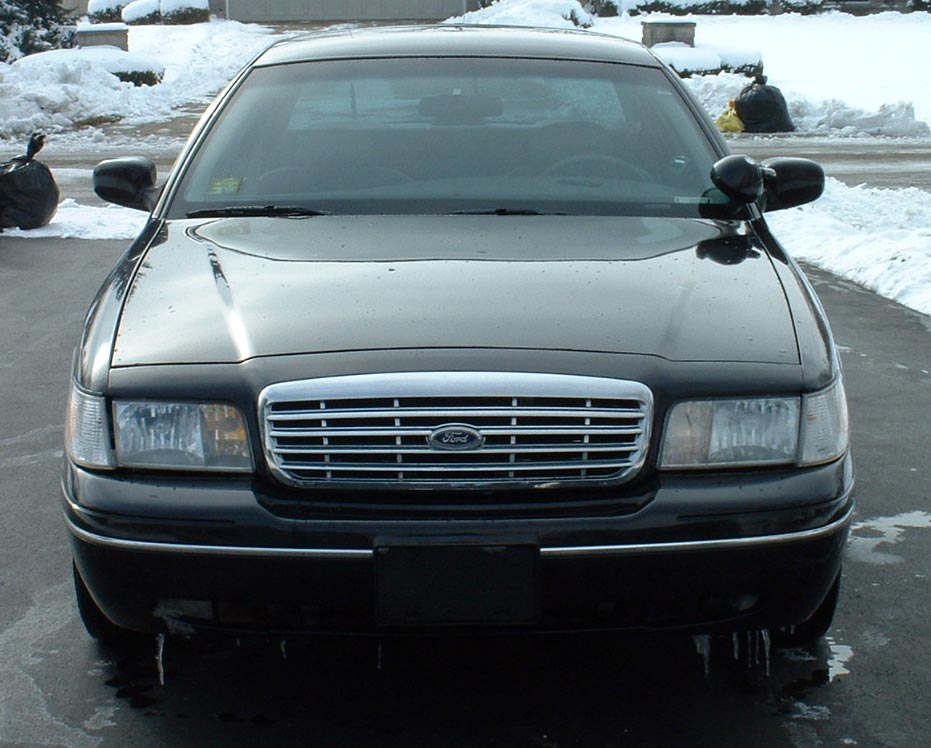 Black 1998 Ford Crown Victoria front view, grille with Ford logo, snow in background
