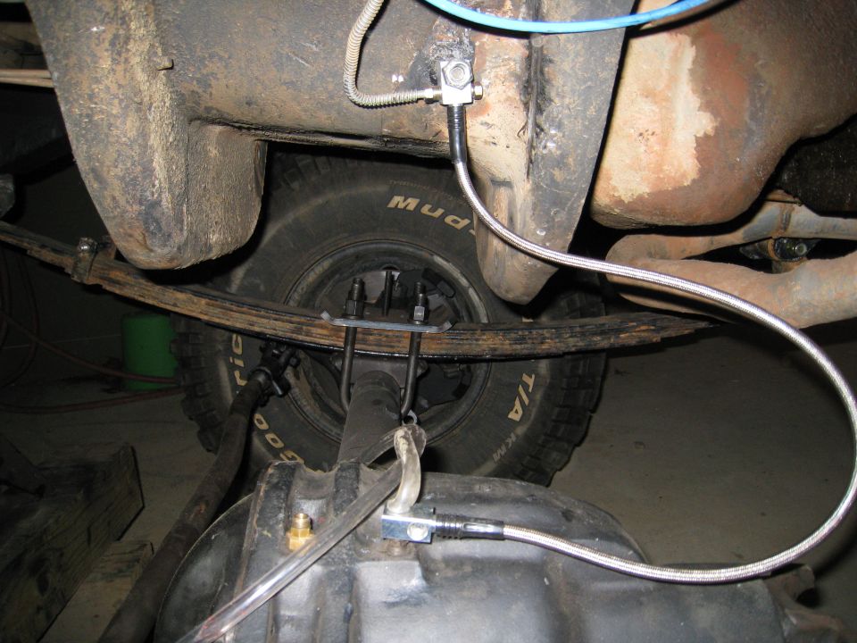 Undercarriage of a vehicle showing a leaf spring, tire, and differential