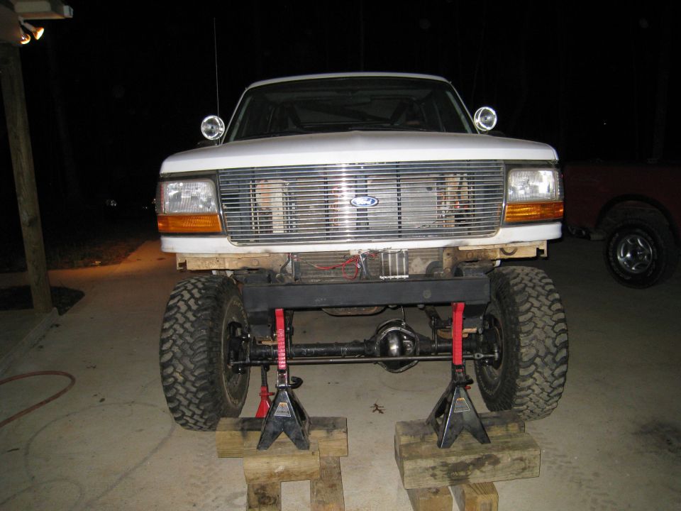 1996 Ford Bronco front end raised on jack stands, showing suspension modification