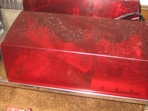 1991 Ford LTD Crown Victoria - Red emergency light bar with chrome trim, showing dust accumulation on the lens.