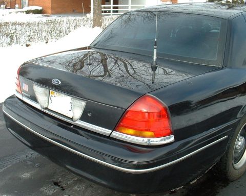 1998 Ford Crown Victoria - The rear of a black 1998 Ford Crown Victoria is shown, its distinctive taillights and a license plate with the number '3'.