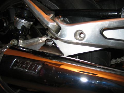 1985 Ford LTD Crown Victoria - Detail shot of a motorcycle's exhaust and rear suspension components.