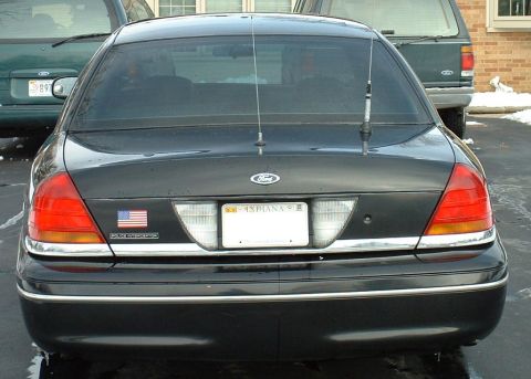 1998 Ford Crown Victoria - Rear view of a 1998 Ford Crown Victoria, showing its taillights, license plate, and an American flag decal.