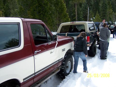 1991 Ford Bronco - Two 1991 Ford Broncos parked in the snow on a wooded trail.