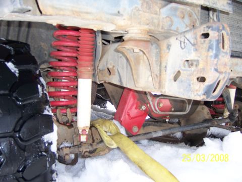 1991 Ford Bronco - Off-road vehicle suspension and tire in snowy conditions.