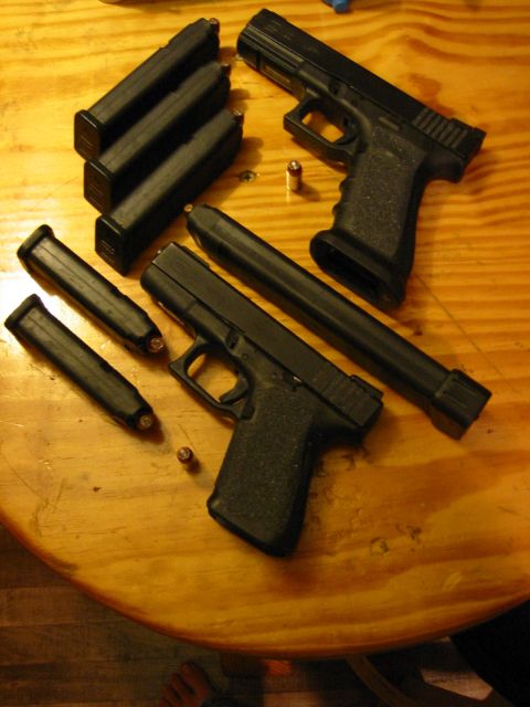 1996 Ford Bronco - Two handguns and multiple magazines are laid out on a wooden surface.