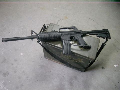1985 Ford Bronco - An assault rifle is placed on top of an ammunition container, with text visible on the side of the can.