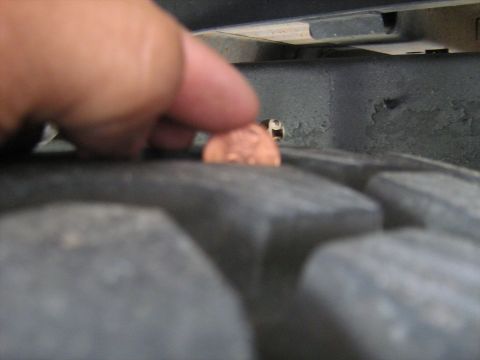 1993 Ford Bronco - A penny is placed on the tread of a vehicle's tire to show depth.