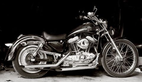 2005 Ford Crown Victoria - A Harley-Davidson Sportster motorcycle is shown in profile against a dark background.