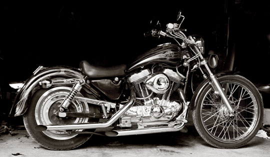 Side view of a black Harley-Davidson Sportster motorcycle with chrome accents