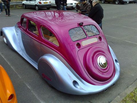 1991 Ford Crown Victoria - A custom hot rod with a pink and silver paint job is parked at an outdoor event with other vehicles.