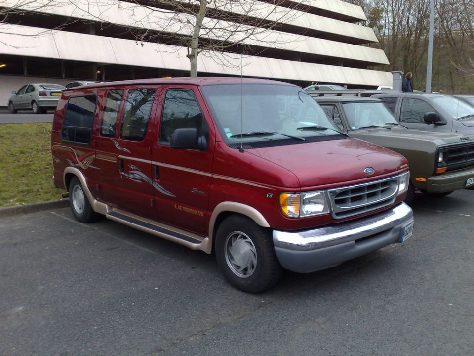 Maroon Ford conversion van parked in a lot