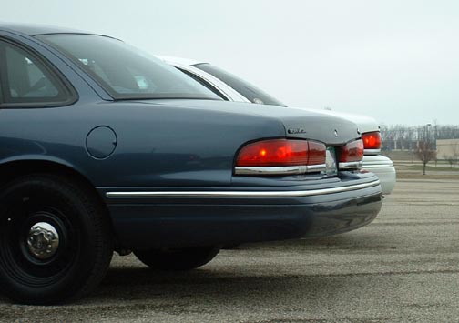 Blue 1998 Ford Crown Victoria rear quarter panel and taillight, another car behind