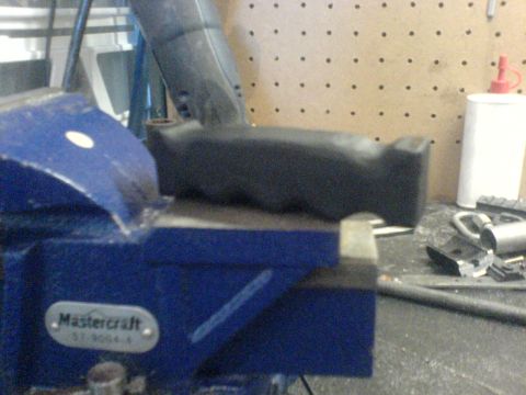 1985 Ford Bronco - A black handle is secured in a blue vise on a workbench.