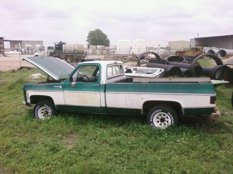 1979 Chevrolet Cheyenne - This pickup truck, likely from the mid-1970s, sits in a yard filled with industrial materials.