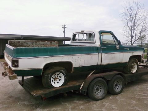 1979 Chevrolet Cheyenne - A white and green pickup truck, likely from the mid-1970s, is loaded onto a trailer.
