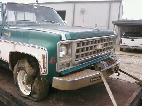 1979 Chevrolet Cheyenne - Flat-tired green Chevrolet pickup truck with winch, parked next to a white pickup. Appears to be a 1977 model.