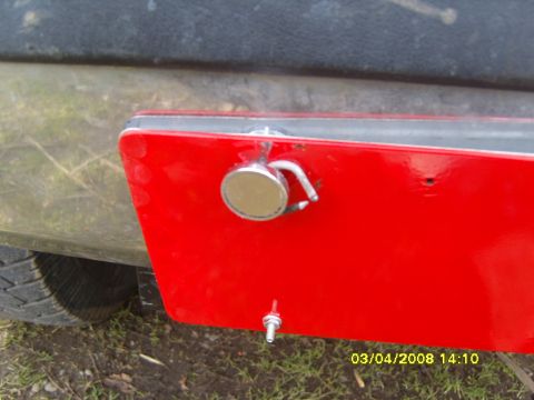 1989 Ford Bronco - A red winch mount is attached to the vehicle's bumper, a silver tow hook and a small bolt below.