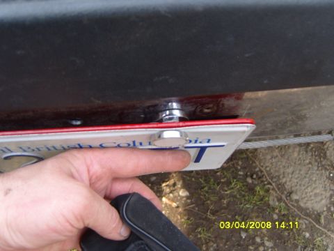 1989 Ford Bronco - A hand is shown attaching a magnetic plate holder to a license plate.
