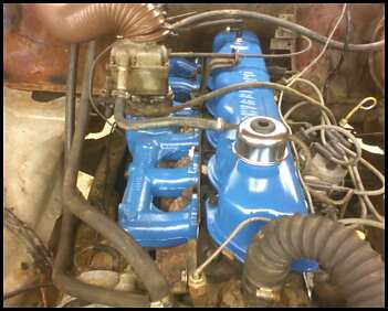 1979 Ford F-150 - Close-up view of an engine bay, blue painted components and the Supermotors logo.