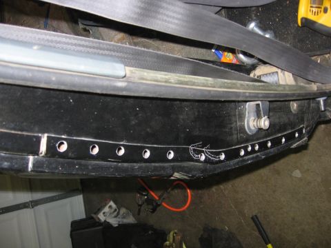 1989 Ford Bronco - Close-up view of a vehicle's interior door sill, showing modifications and a seatbelt.