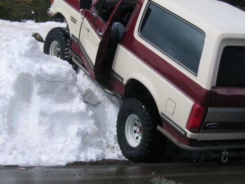 1991 Ford Bronco - Ford Bronco stuck in deep snow with the driver's door open.