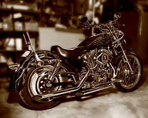 2005 Ford Crown Victoria - A custom motorcycle with flame detailing on the fuel tank and extensive chrome accents is shown from a three-quarter front view.