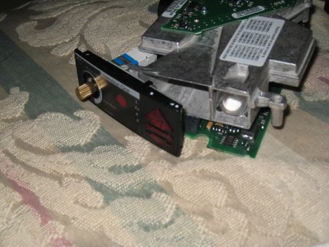 2007 Subaru Impreza - Close-up of a Valentine One radar detector, showing its distinctive front panel with a gold adjustment knob and a red alert button.