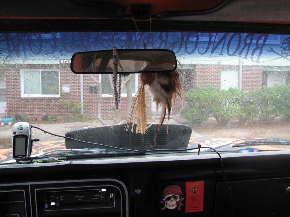 Bronco dash and rearview mirror seen from inside, windshield lettered BRONCORACING.COM