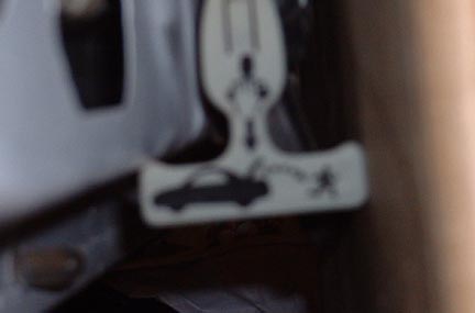 1998 Ford Crown Victoria - A white plastic part with a silhouette of a car and a stick figure is visible.