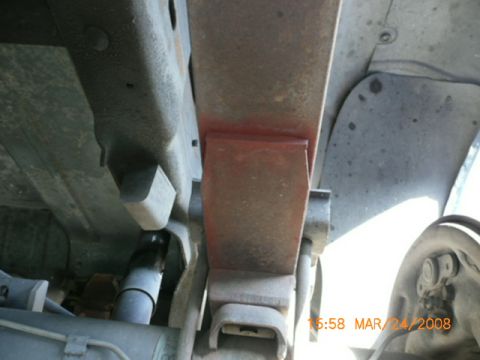 1991 Ford Bronco - Close-up view of the undercarriage, focusing on the suspension components including leaf springs and a shock absorber.
