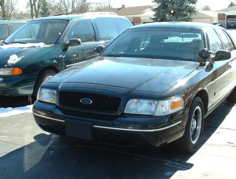 1998 Ford Crown Victoria - A black 1998 Ford Crown Victoria is parked next to another vehicle.