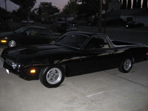 1970 Ford Ranchero - A black 1970 Ford Ranchero is parked in a driveway at dusk, with other vehicles visible in the background.
