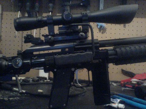 1985 Ford Bronco - A sniper rifle equipped with a scope is shown in detail.
