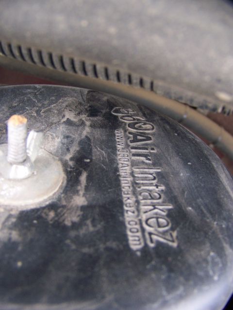 2001 Dodge 1500 - Close-up of a dusty air intake hose with a website address embossed on it.