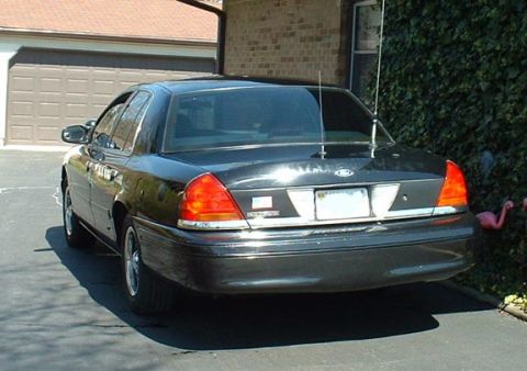 1998 Ford Crown Victoria - Rear view of a 1998 Ford Crown Victoria parked outside a garage.