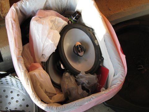 1995 Ford Bronco - Car speakers are discarded in a trash bag along with other items.
