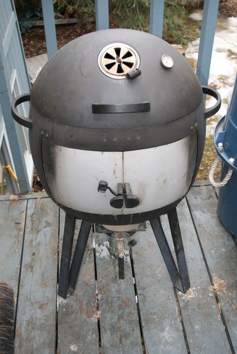 2003 Jeep TJ - A smoker grill with a thermometer sits on a weathered wooden deck.