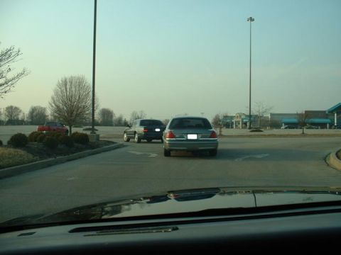 1998 Ford Crown Victoria - A gray Ford Crown Victoria is seen from the rear in a parking lot, with another vehicle behind it.