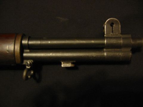 1996 Ford Bronco - A close-up view of a rifle's barrel and rear sight assembly against a dark background.