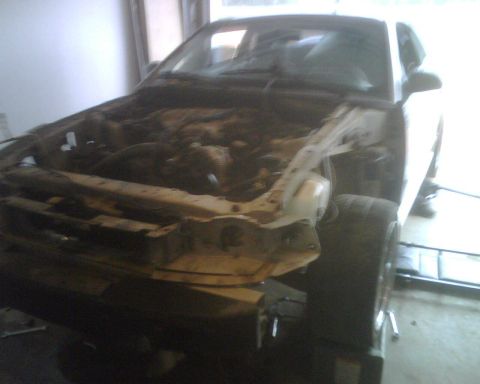 1999 Ford Mustang - Front end of a 1999 Ford Mustang removed to access the engine bay.